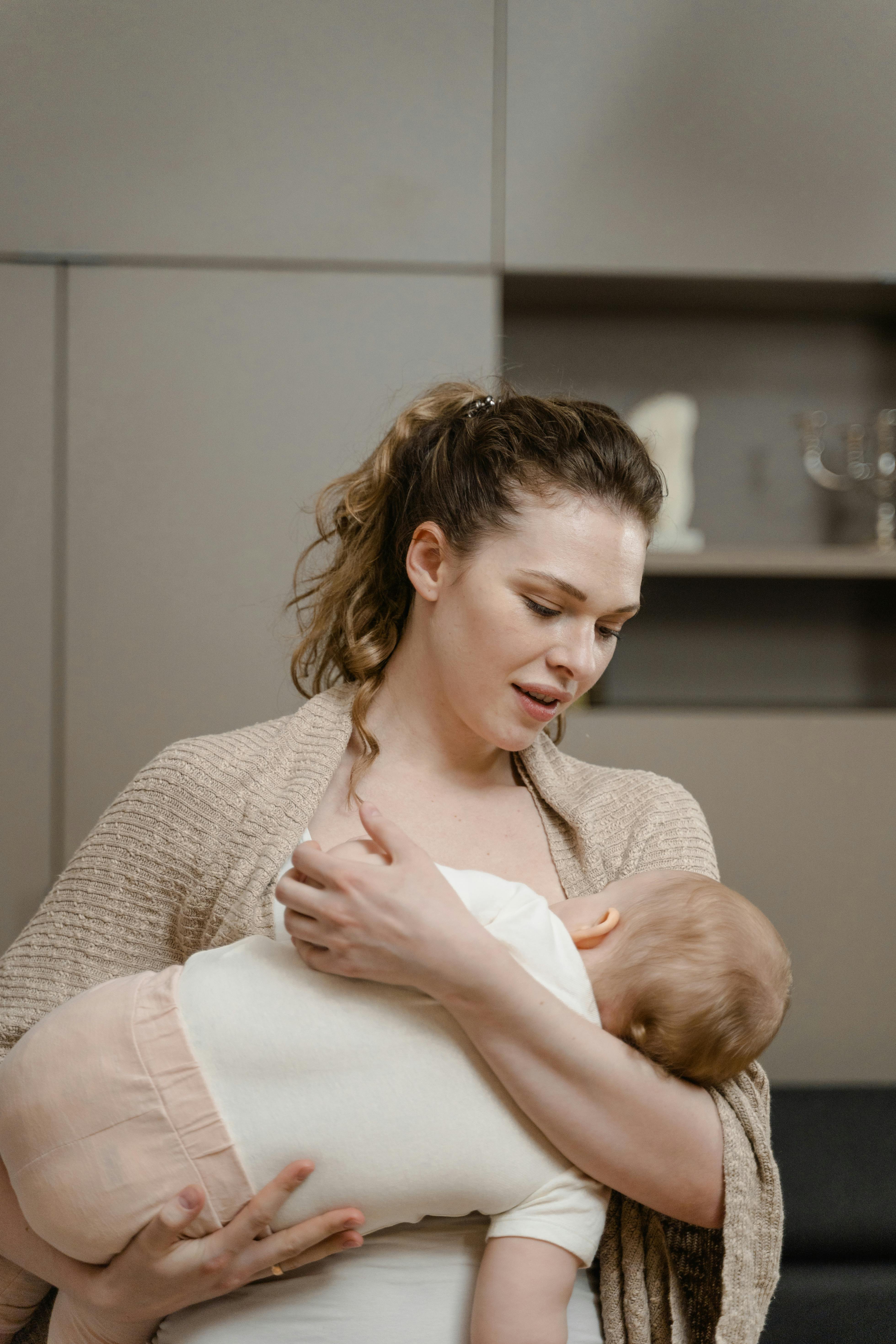 Kobieta trzymająca niemowlę w ramionach – przykład prawidłowej pielęgnacji i bliskości wspierającej rozwój wcześniaka.